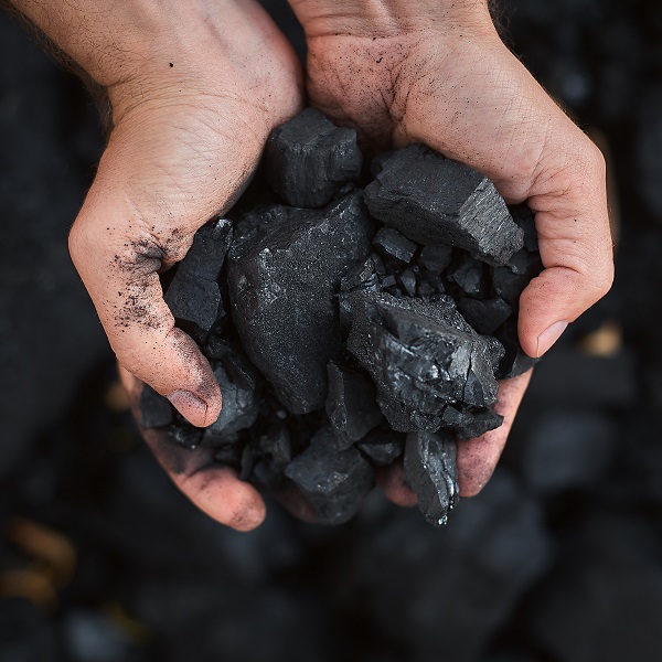 poor middle-aged man holding the hands of stone coal for sale